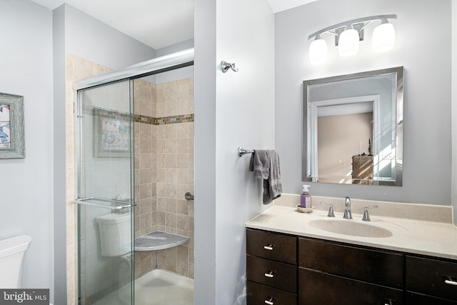 bathroom featuring vanity, toilet, and walk in shower