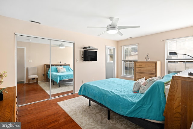 bedroom featuring ceiling fan, dark hardwood / wood-style floors, and a closet