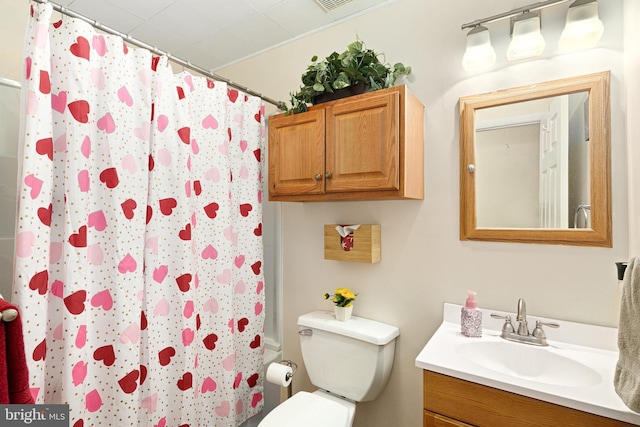 bathroom featuring vanity, curtained shower, and toilet