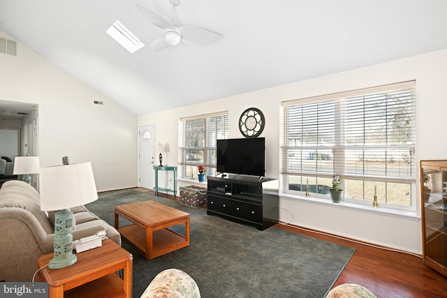 living room featuring ceiling fan, dark hardwood / wood-style floors, a skylight, and high vaulted ceiling