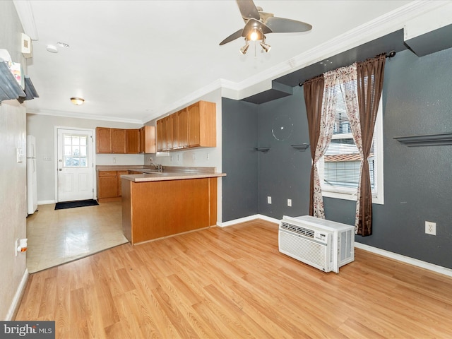 kitchen with crown molding, a wall mounted air conditioner, white refrigerator, kitchen peninsula, and light hardwood / wood-style floors