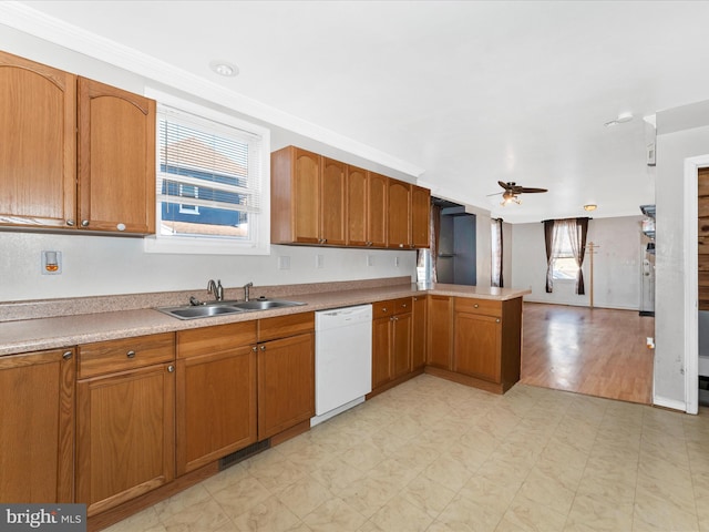 kitchen featuring a healthy amount of sunlight, dishwasher, sink, and kitchen peninsula