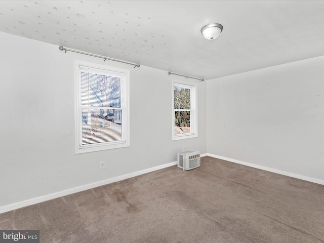 carpeted empty room with a wall unit AC