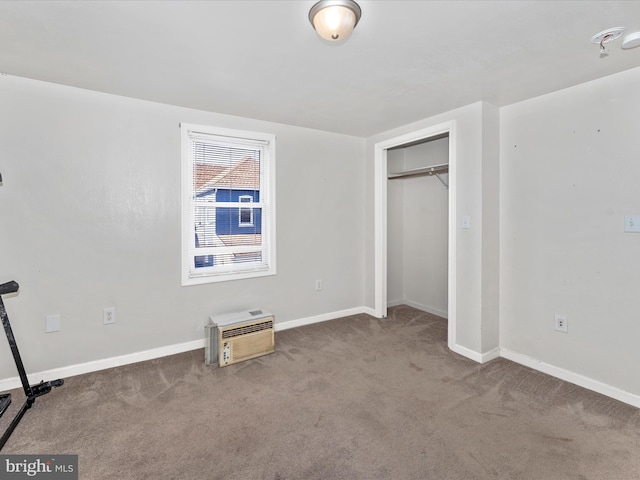 unfurnished bedroom with carpet floors, a wall mounted AC, and a closet