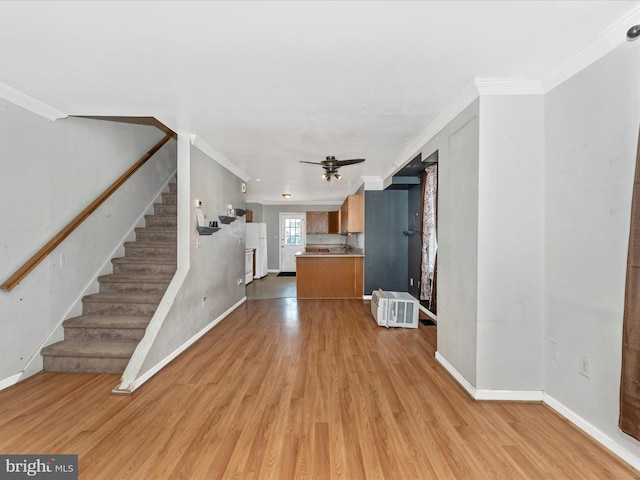 unfurnished living room with light hardwood / wood-style flooring, ornamental molding, and ceiling fan