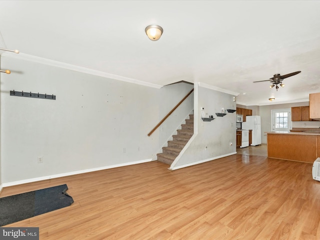 unfurnished living room featuring crown molding, ceiling fan, and light wood-type flooring