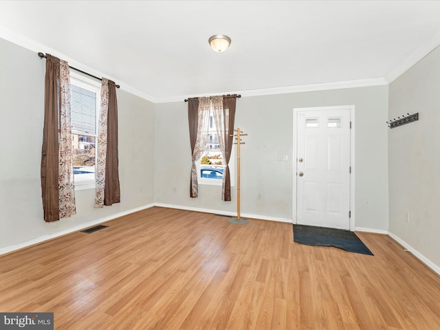 foyer entrance with crown molding and light hardwood / wood-style flooring