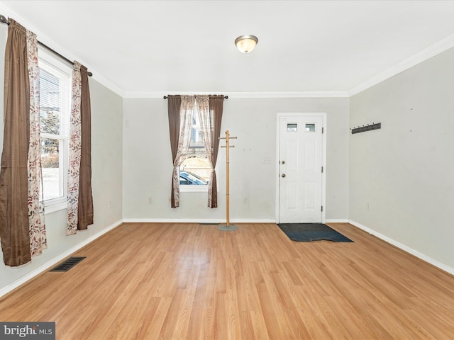 entrance foyer with ornamental molding and light hardwood / wood-style floors