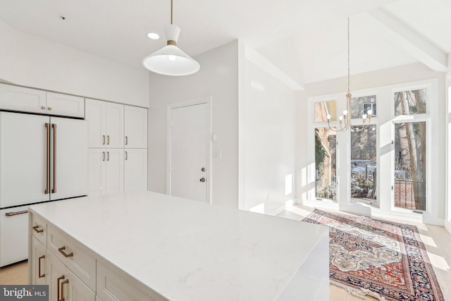 kitchen with white cabinetry, high end fridge, a healthy amount of sunlight, and decorative light fixtures