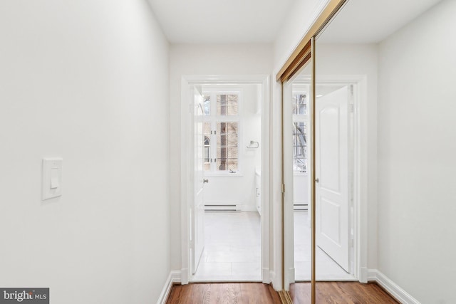 hall featuring hardwood / wood-style floors and baseboard heating