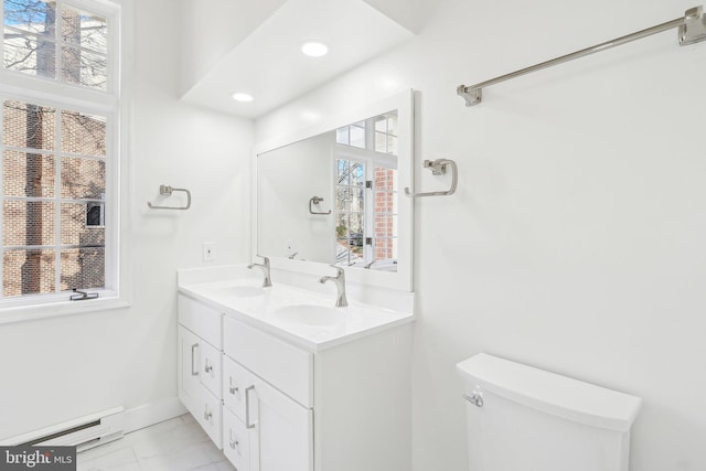 bathroom with vanity, toilet, and baseboard heating