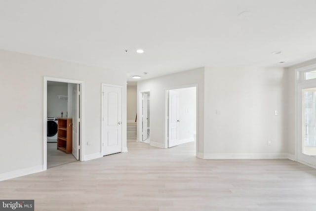 empty room featuring washer / dryer and light hardwood / wood-style flooring