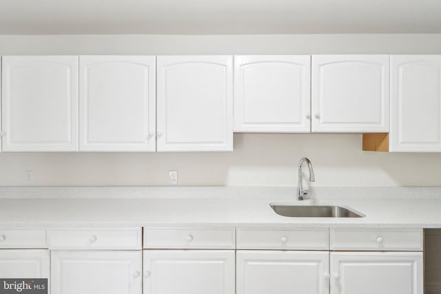 kitchen featuring white cabinetry and sink