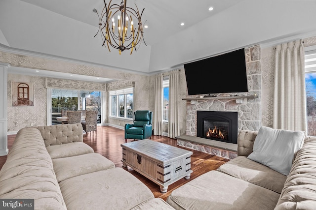 living room featuring hardwood / wood-style flooring, a chandelier, a high ceiling, and a fireplace