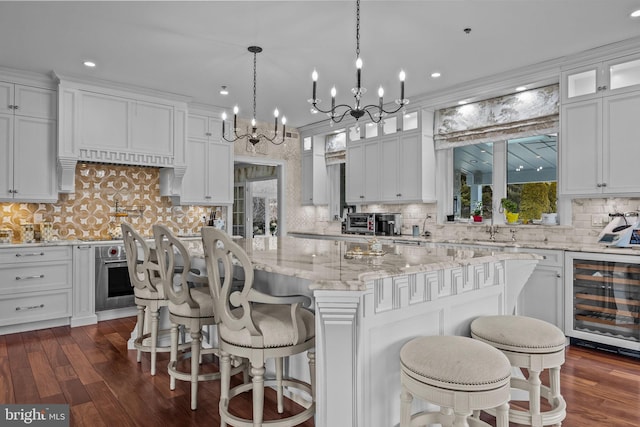 kitchen featuring a kitchen island, white cabinetry, and wine cooler