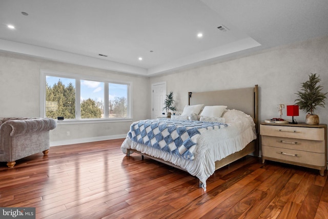 bedroom featuring a tray ceiling and dark hardwood / wood-style floors