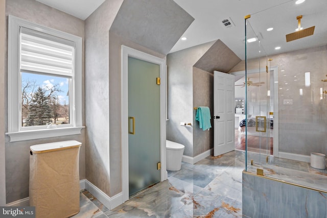 bathroom featuring ceiling fan, toilet, and a shower with door