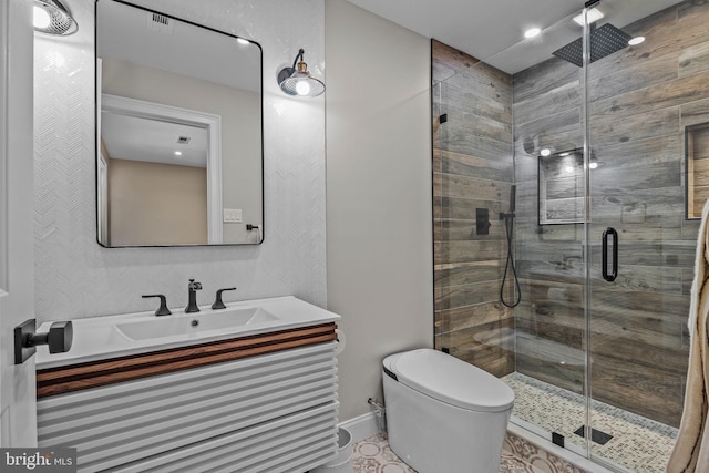 bathroom featuring toilet, a shower with door, and vanity