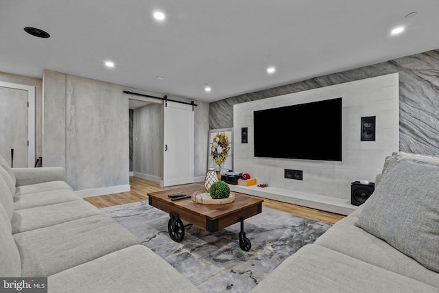 living room featuring a barn door and light wood-type flooring