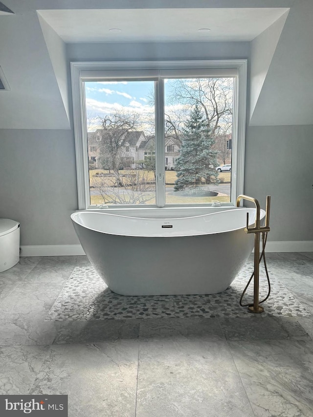 bathroom featuring a bath and a wealth of natural light