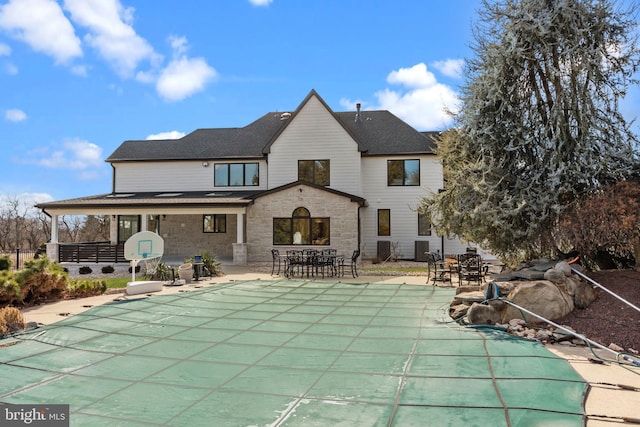 back of house featuring a covered pool and a patio area