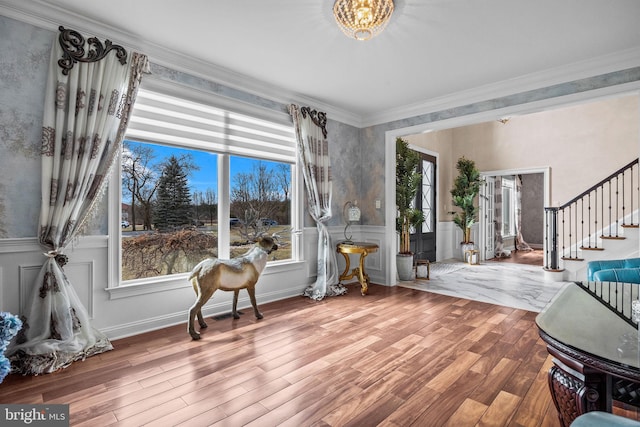 living area with wood-type flooring and crown molding