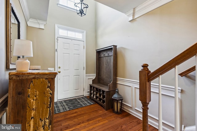 foyer entrance with crown molding and dark hardwood / wood-style floors