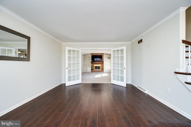 unfurnished living room featuring dark hardwood / wood-style floors, a fireplace, french doors, and crown molding