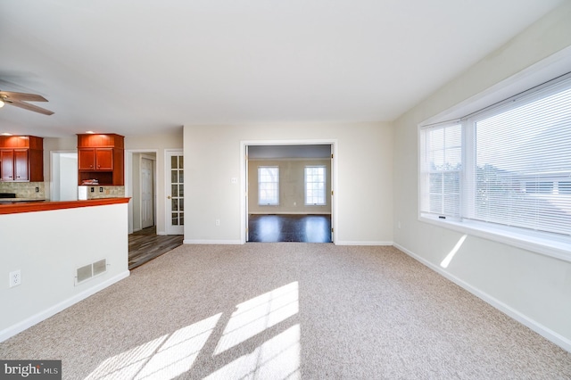 unfurnished living room with ceiling fan and light colored carpet