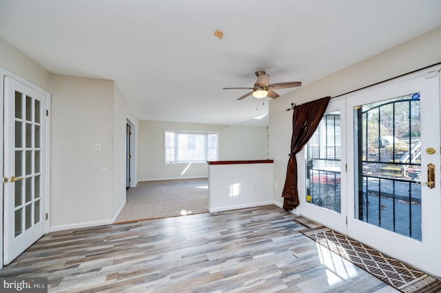 unfurnished room with ceiling fan, light hardwood / wood-style floors, and french doors