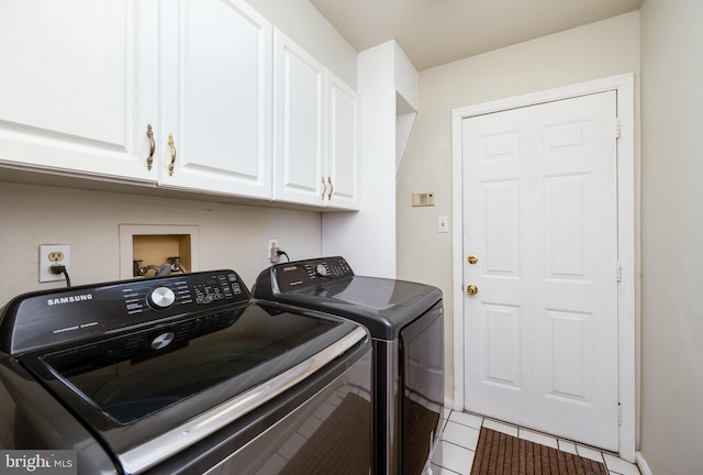 laundry room featuring cabinets, washing machine and clothes dryer, and light tile patterned flooring