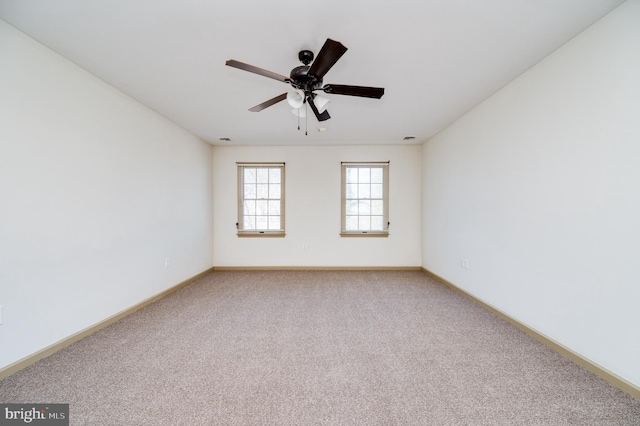 carpeted spare room featuring ceiling fan