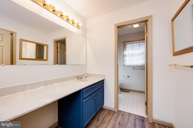 bathroom featuring vanity, hardwood / wood-style floors, and toilet