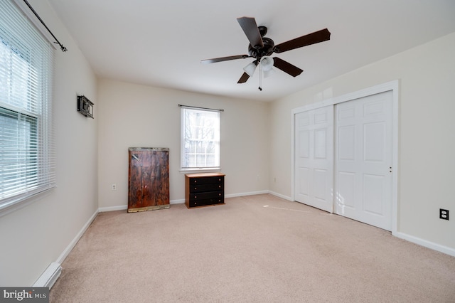 unfurnished bedroom with light carpet, ceiling fan, and a closet