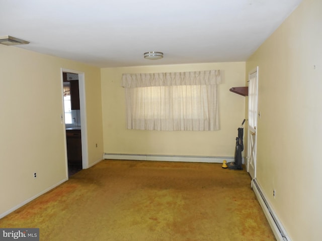 carpeted spare room featuring a baseboard heating unit