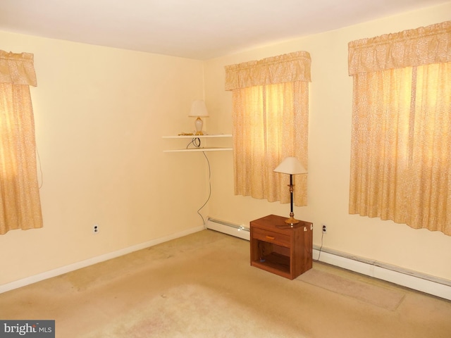 carpeted empty room with a baseboard heating unit