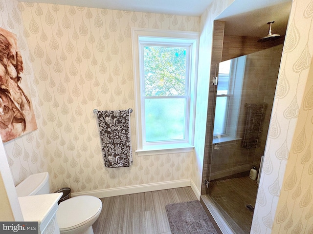 bathroom with a tile shower, hardwood / wood-style floors, vanity, and toilet