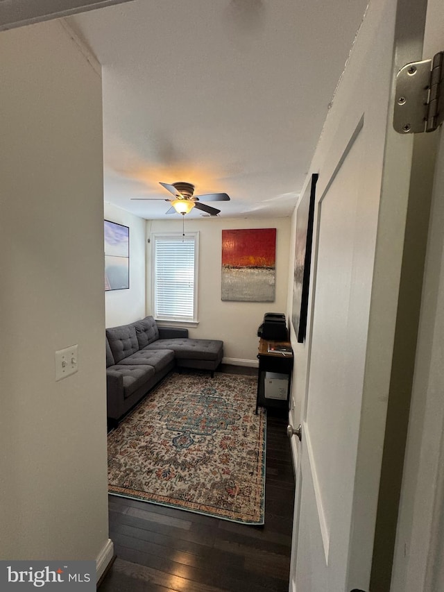 living room featuring wood-type flooring and ceiling fan