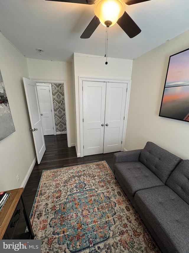 living room featuring dark hardwood / wood-style floors and ceiling fan