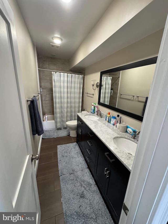 full bathroom featuring vanity, shower / bath combination with curtain, and toilet