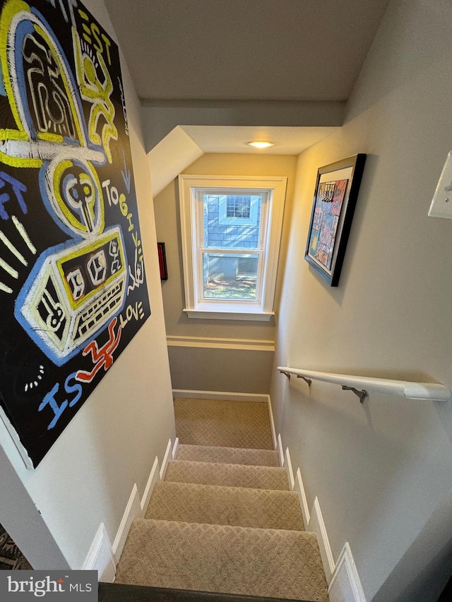 staircase with vaulted ceiling and carpet flooring