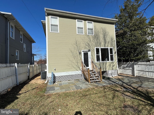 rear view of house with a patio, cooling unit, and a lawn