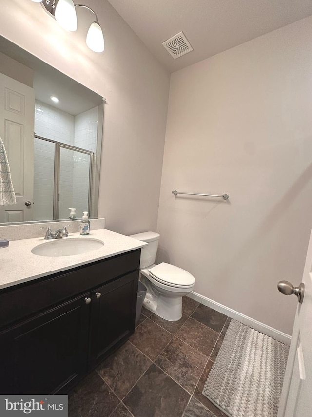 bathroom featuring a shower with door, vanity, and toilet