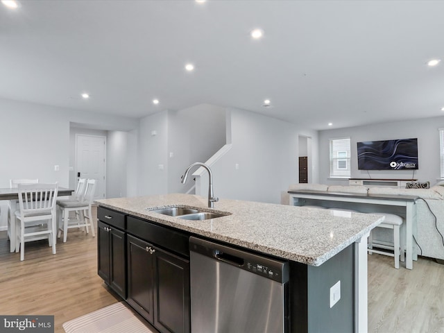 kitchen with sink, dishwasher, a kitchen island with sink, and light hardwood / wood-style flooring