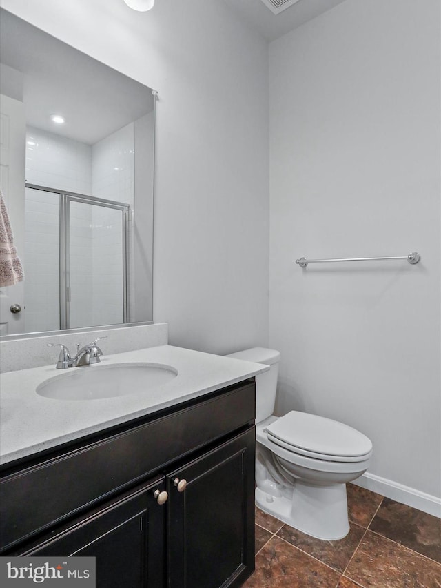 bathroom featuring a shower with door, vanity, and toilet