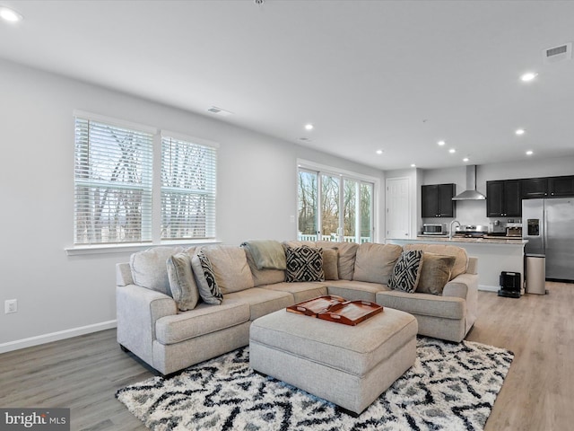 living room featuring sink and light hardwood / wood-style floors