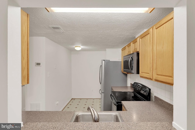 kitchen featuring stainless steel appliances, sink, decorative backsplash, and light brown cabinets