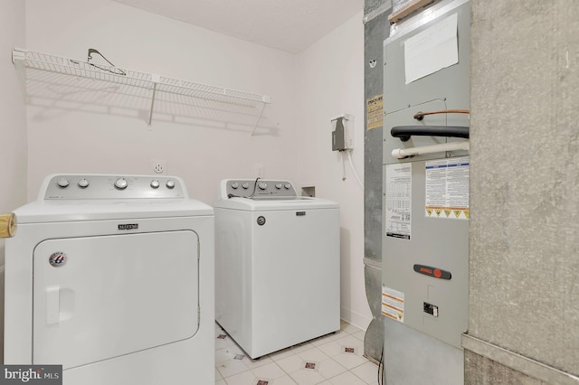 washroom with separate washer and dryer, heating unit, and light tile patterned floors