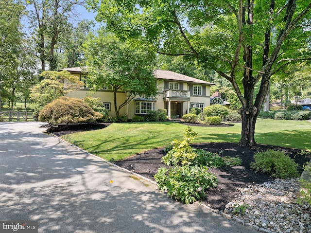 view of front of property featuring a balcony and a front yard