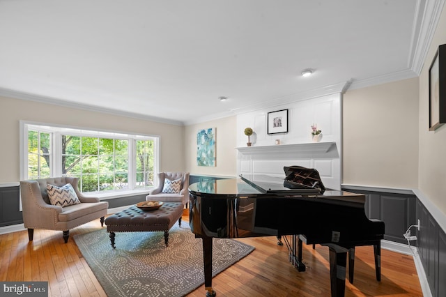 sitting room featuring crown molding and light hardwood / wood-style flooring